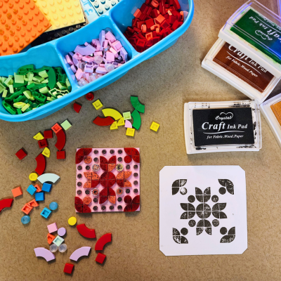 lego dots on a table with stamp pads and a print made from the legos