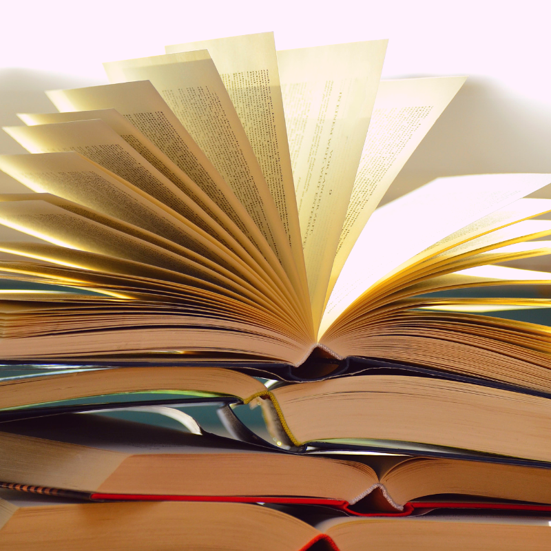 An open book sitting on top of a stack of books